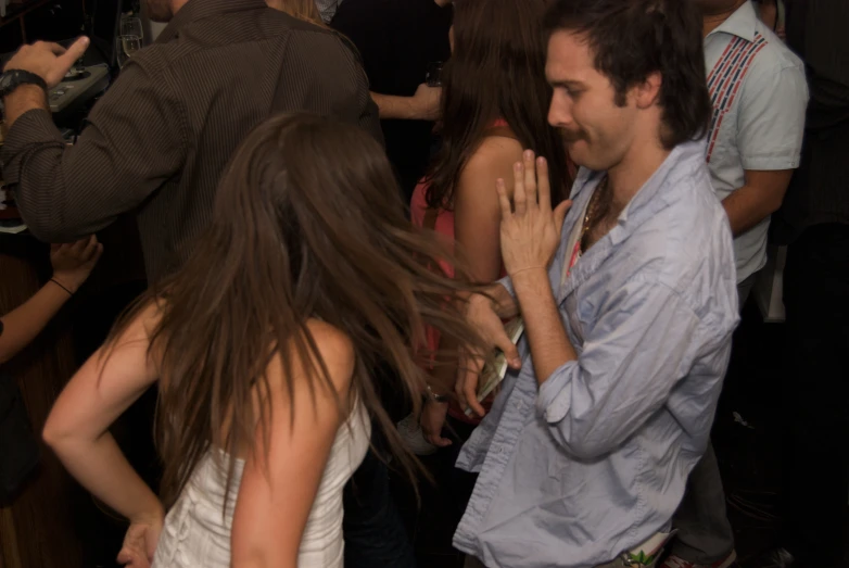 several people dancing at a party in the dark