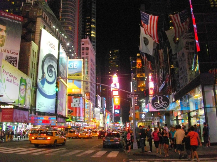 a city street at night with many people, cars and vehicles