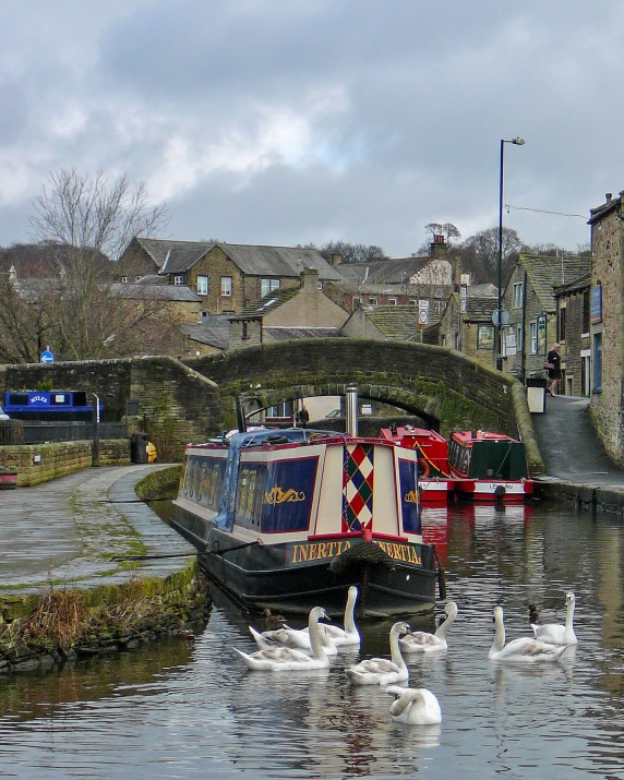 the boats are floating in the water beside the road bridge