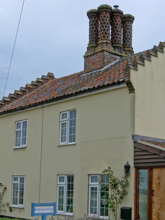 a house with chimneys and some big windows