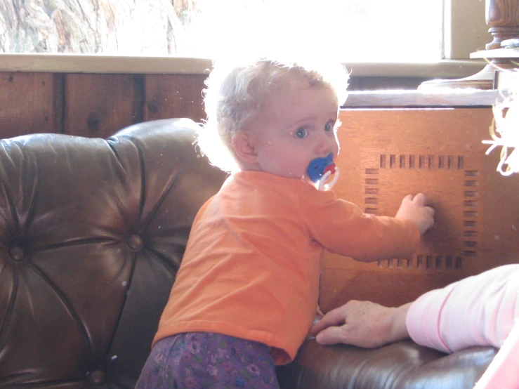 a little girl plays with a clock on a couch