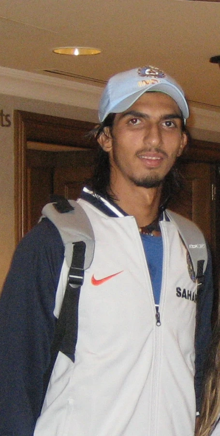 a man wearing a blue hat and jacket in front of a door