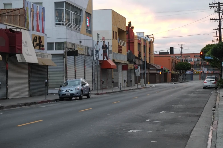 a city street with traffic and buildings and several cars parked at curb