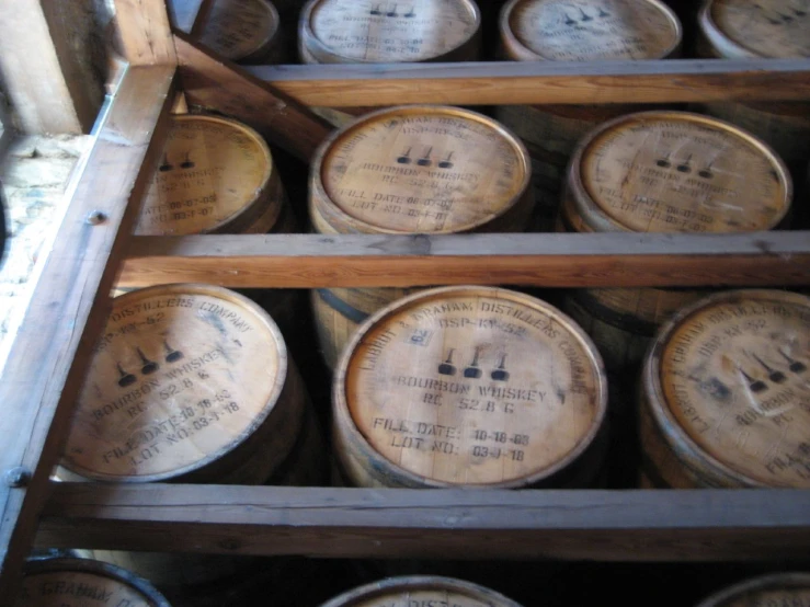 barrels with labels in wooden storage shelves in cellar