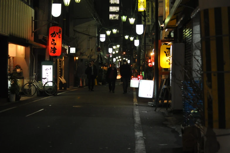 an alley at night with people and signs