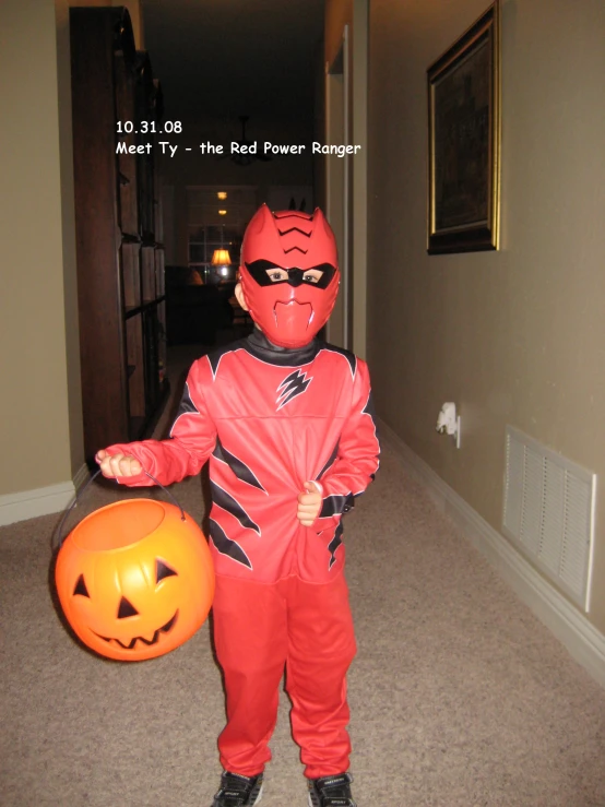 the child in red is wearing a red and black costume with a pumpkin