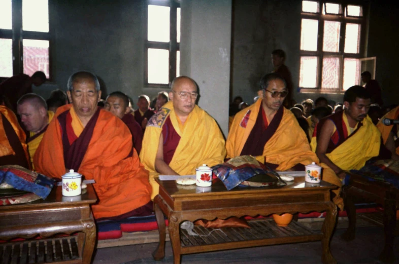 the monks are seated in a large group