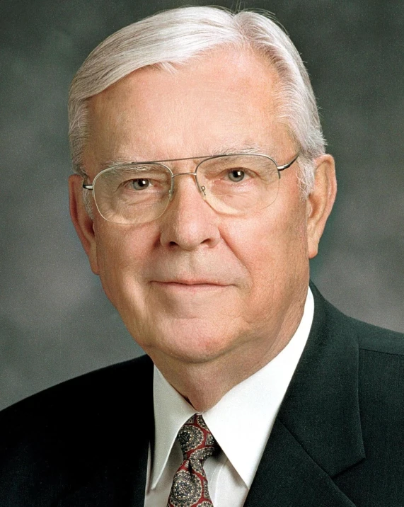 a man wearing glasses, a tie and a jacket