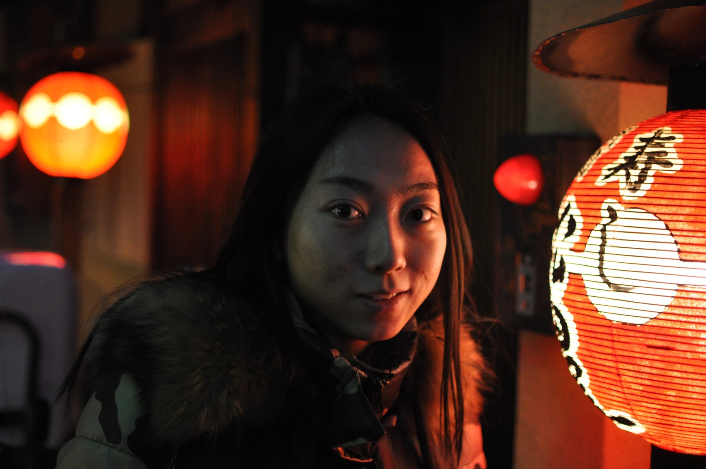 a woman sitting in front of an oriental lamp