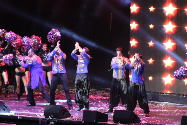 a group of people are standing on stage in front of the audience