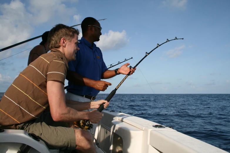 two men fishing on the front of a boat