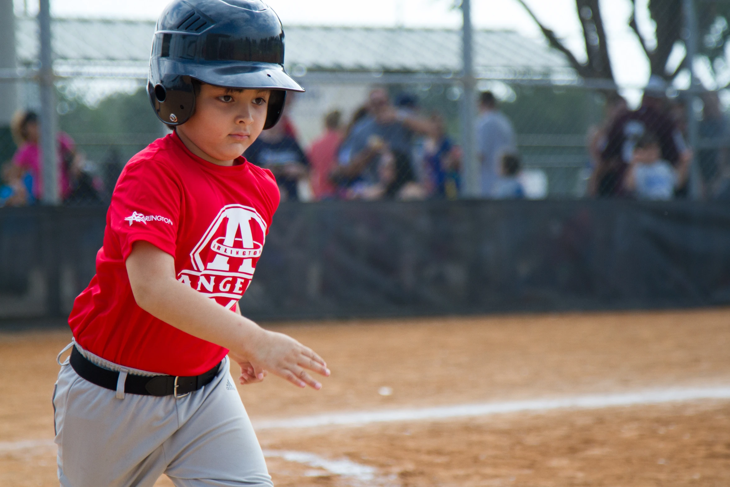 young  in red jersey and helmet playing baseball