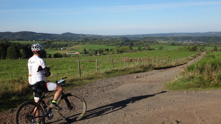 the bicyclist is going down the hill with his bike