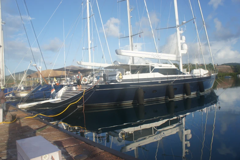 a large blue boat at a dock next to other boats