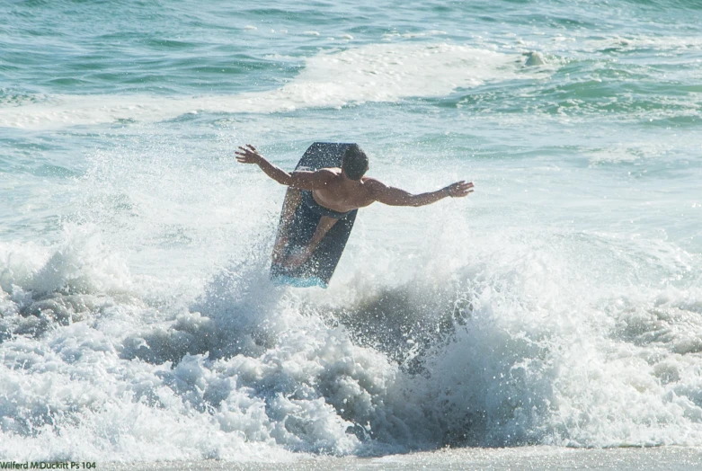 a man standing in water while falling off his surfboard