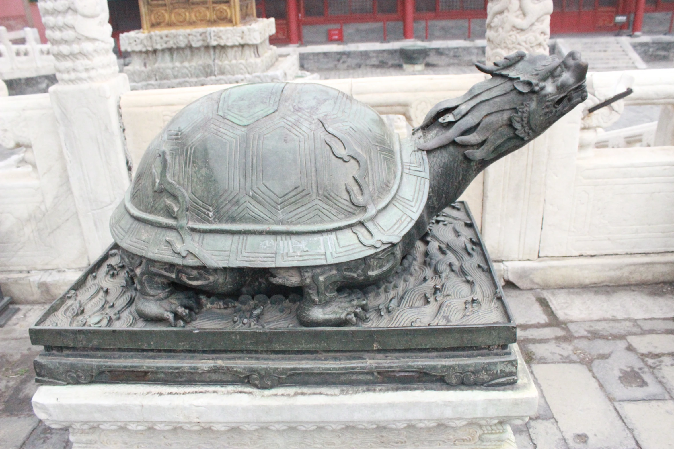 a metal turtle statue on display with its head facing the camera