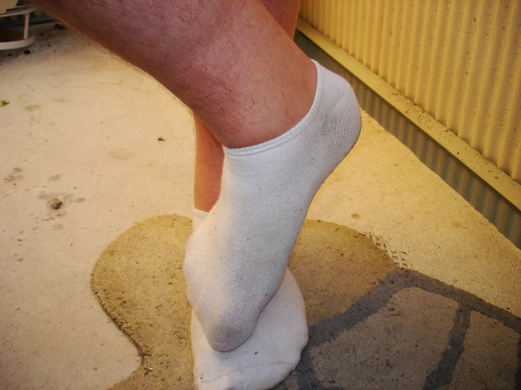 close up view of a persons bare feet and white socks