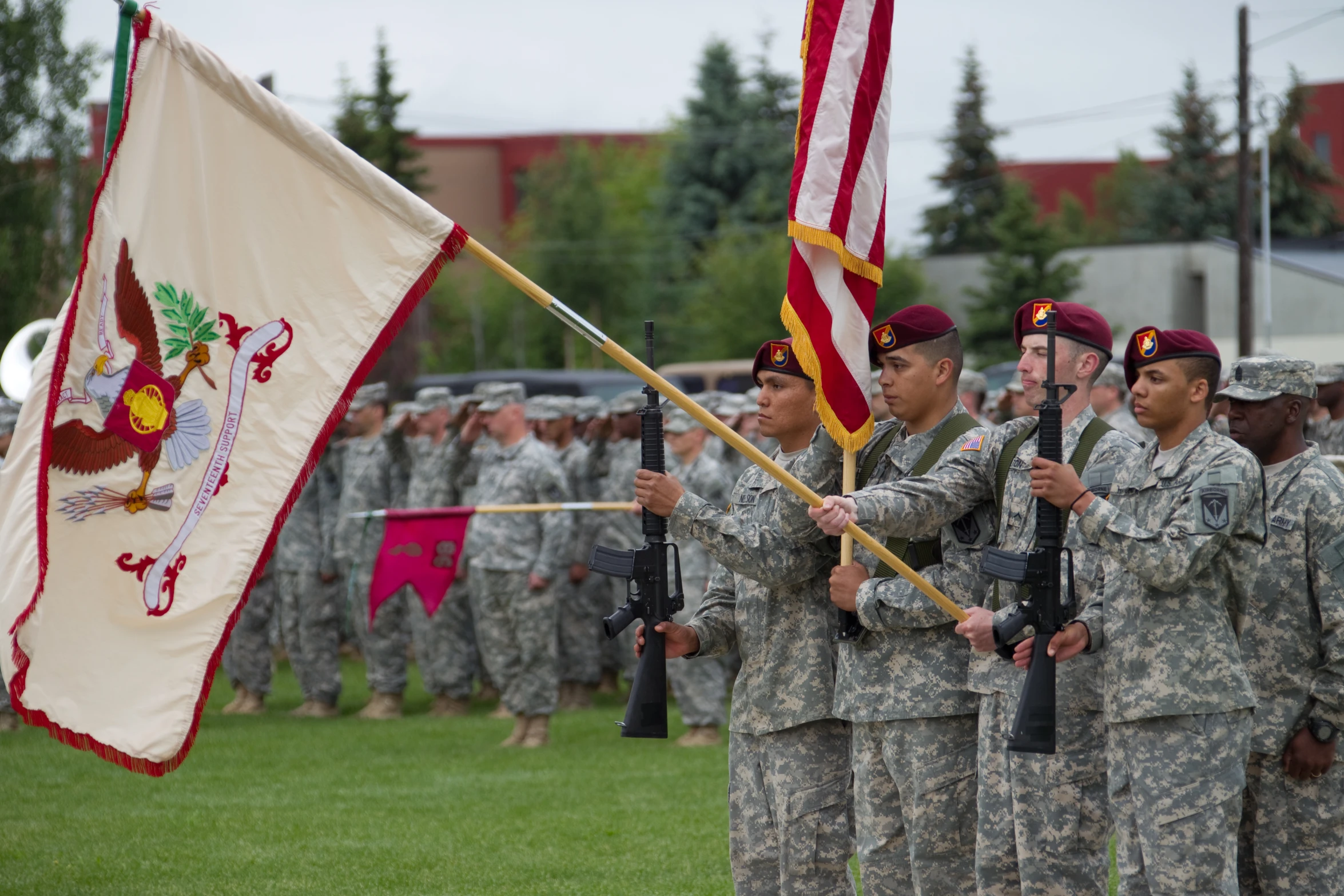 some soldiers stand near flags at a ceremony