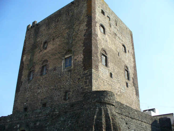 an old brick tower with windows and ivy growing from it