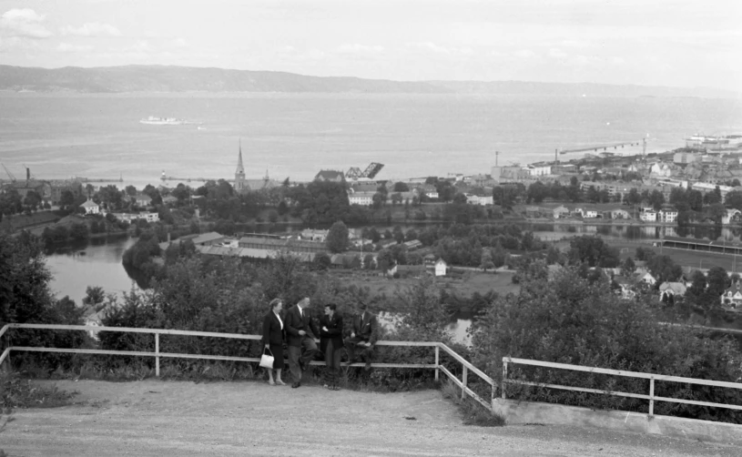 two people walking across a balcony towards the sea