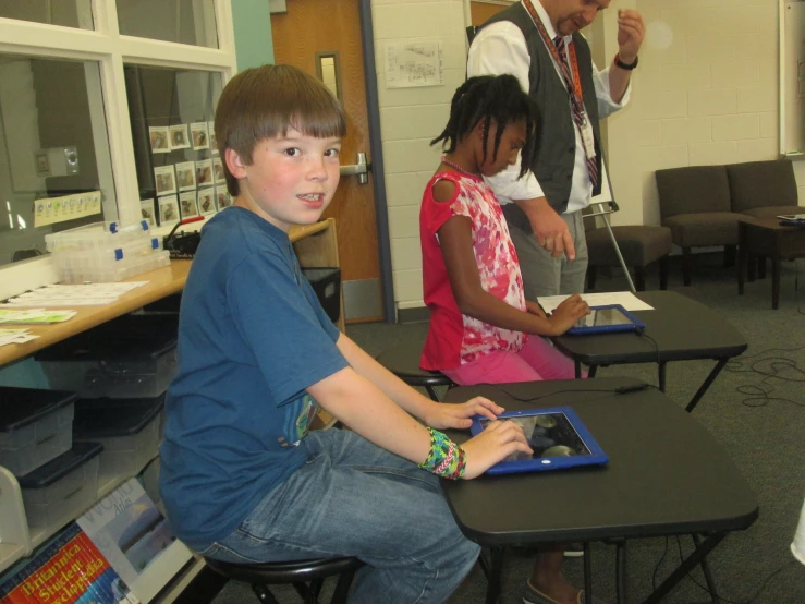 three young s sitting in front of their laptops