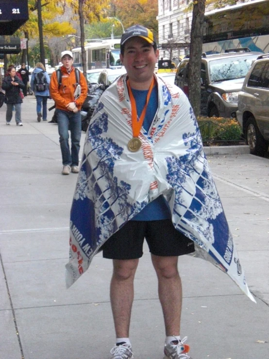 a man is holding onto his towel while he wears a cap and shorts