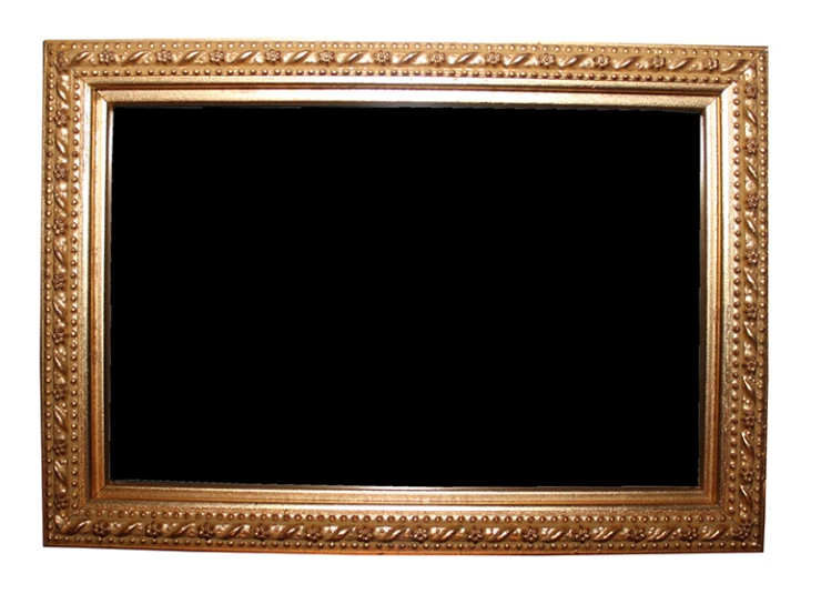 an antique gold frame hanging up against a white wall