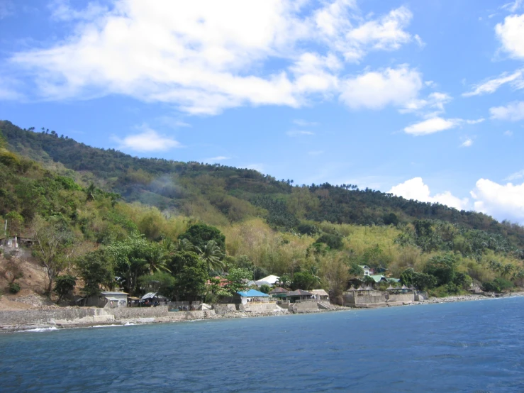 a scenic view of a beach and the hills in the distance