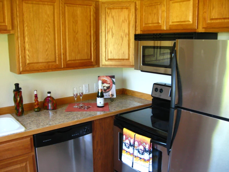 a kitchen with silver appliances and light oak cabinets