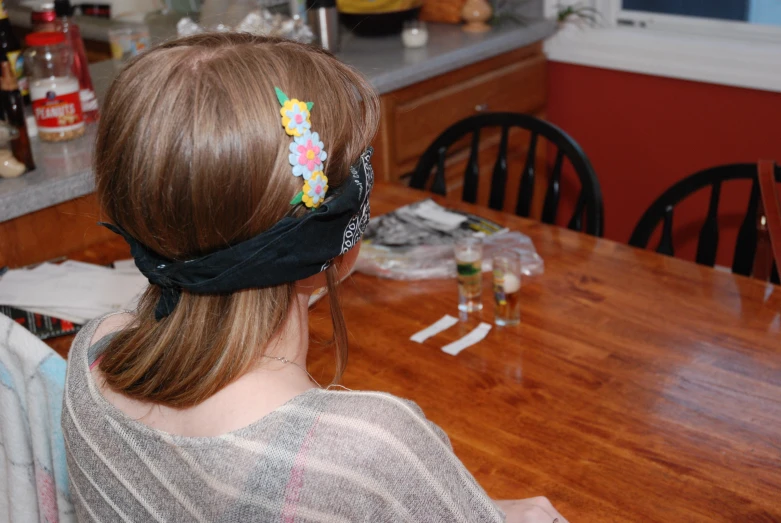 a girl in a grey sweater is sitting at the table