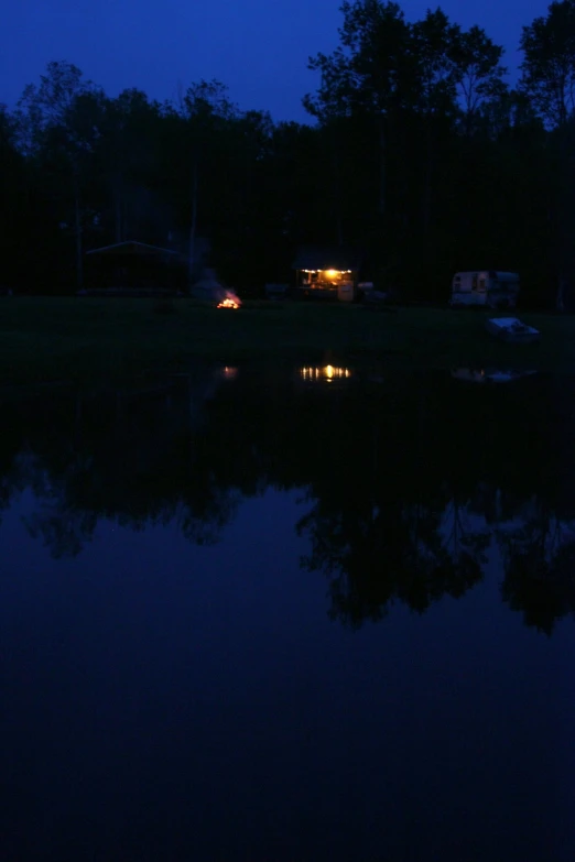 two campers are sitting in the shade at night