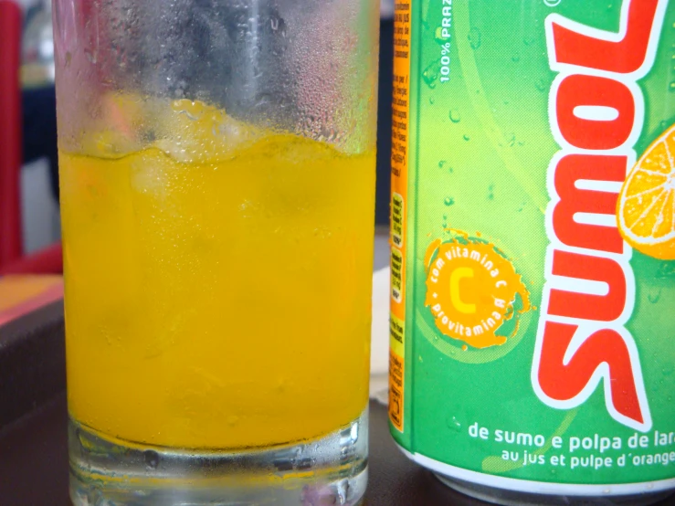 an orange drink is next to a soda bottle