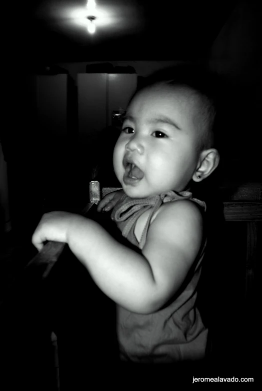 a child is sitting down in the dark with its hands on a remote control