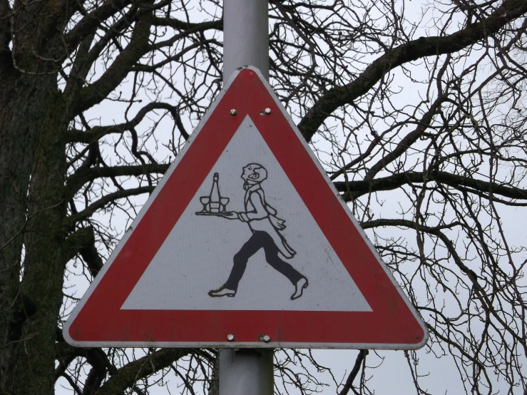 a red and white street sign is hanging from a tree