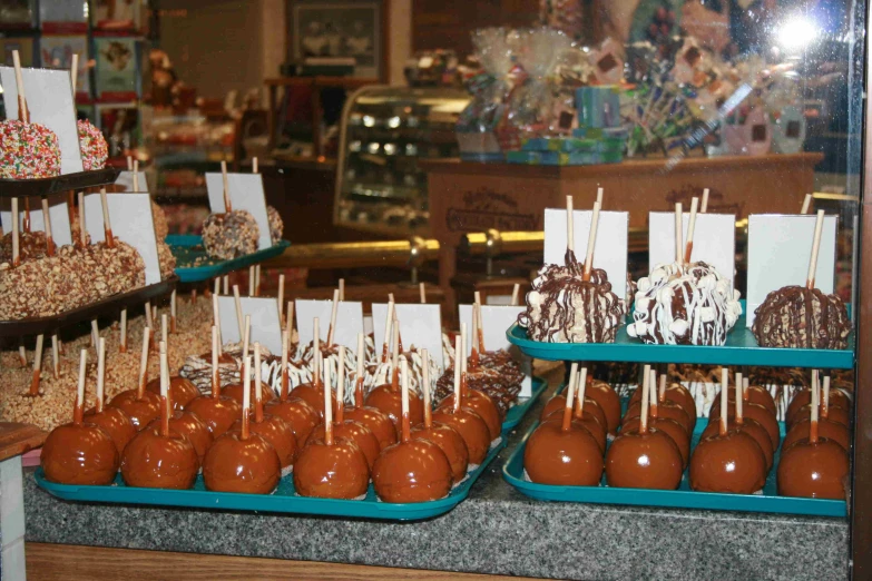 several chocolates, candy pops and other pastries are on display in front of a store
