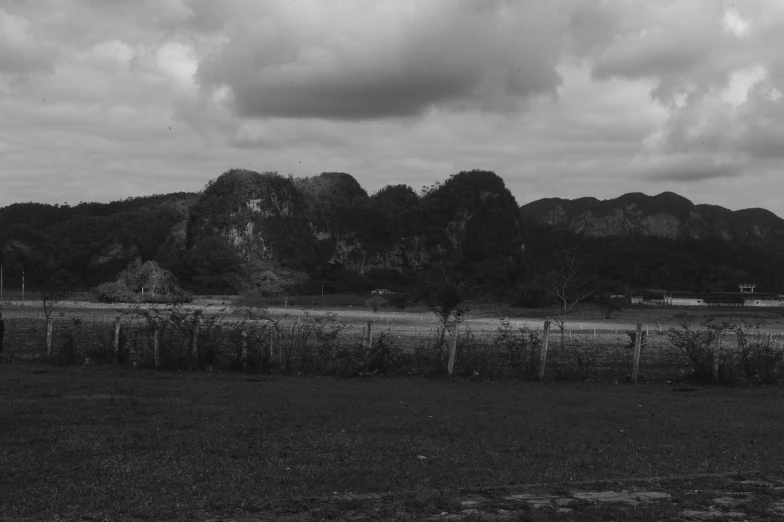 black and white pograph of mountains with fence