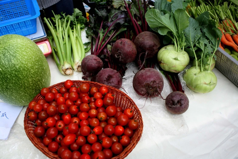 fresh produce including tomatoes, celery, turnips, and spinach sitting on a table