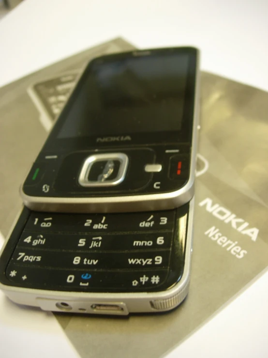 a cell phone sitting on top of a gray book