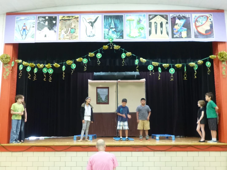 a group of s standing on top of a stage