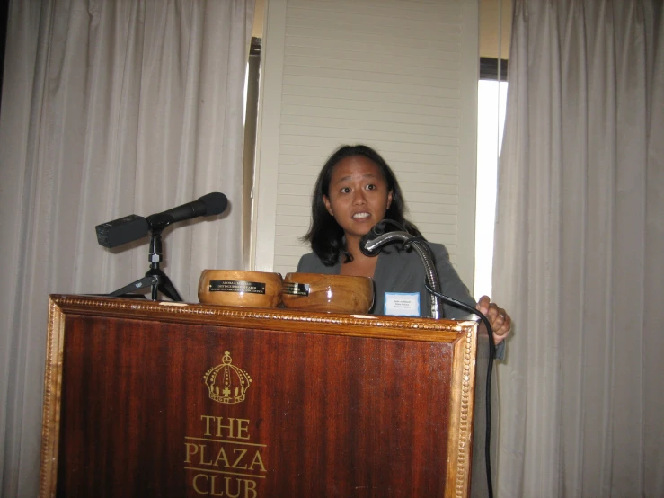 a woman speaking at a podium with a microphone