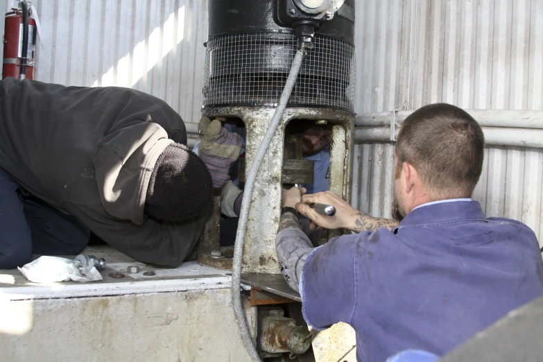 a man fixing some pipe in a building