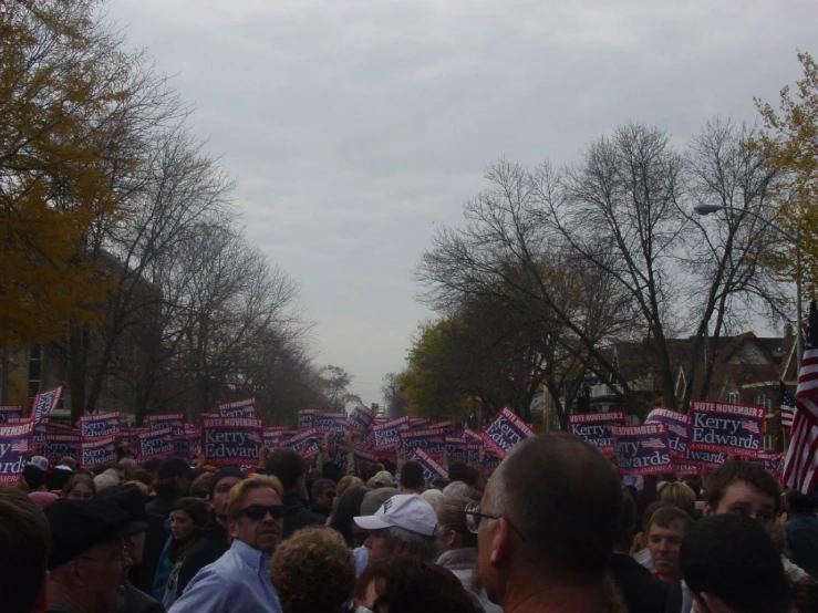 a large crowd of people holding signs on the street