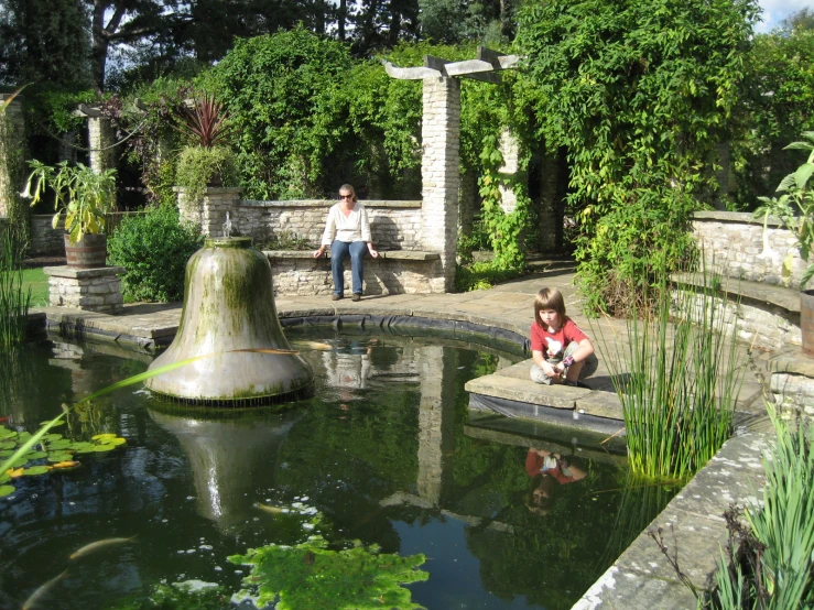 two people are at the pond in the park