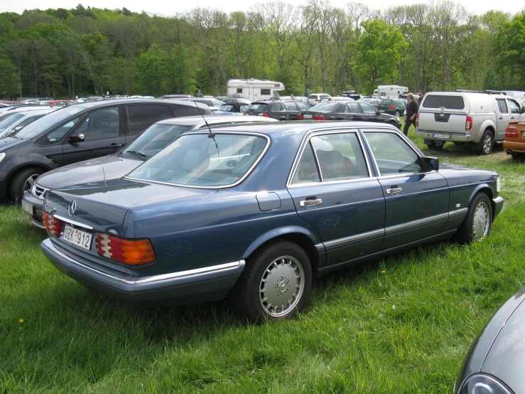 an old mercedes is parked next to the other cars