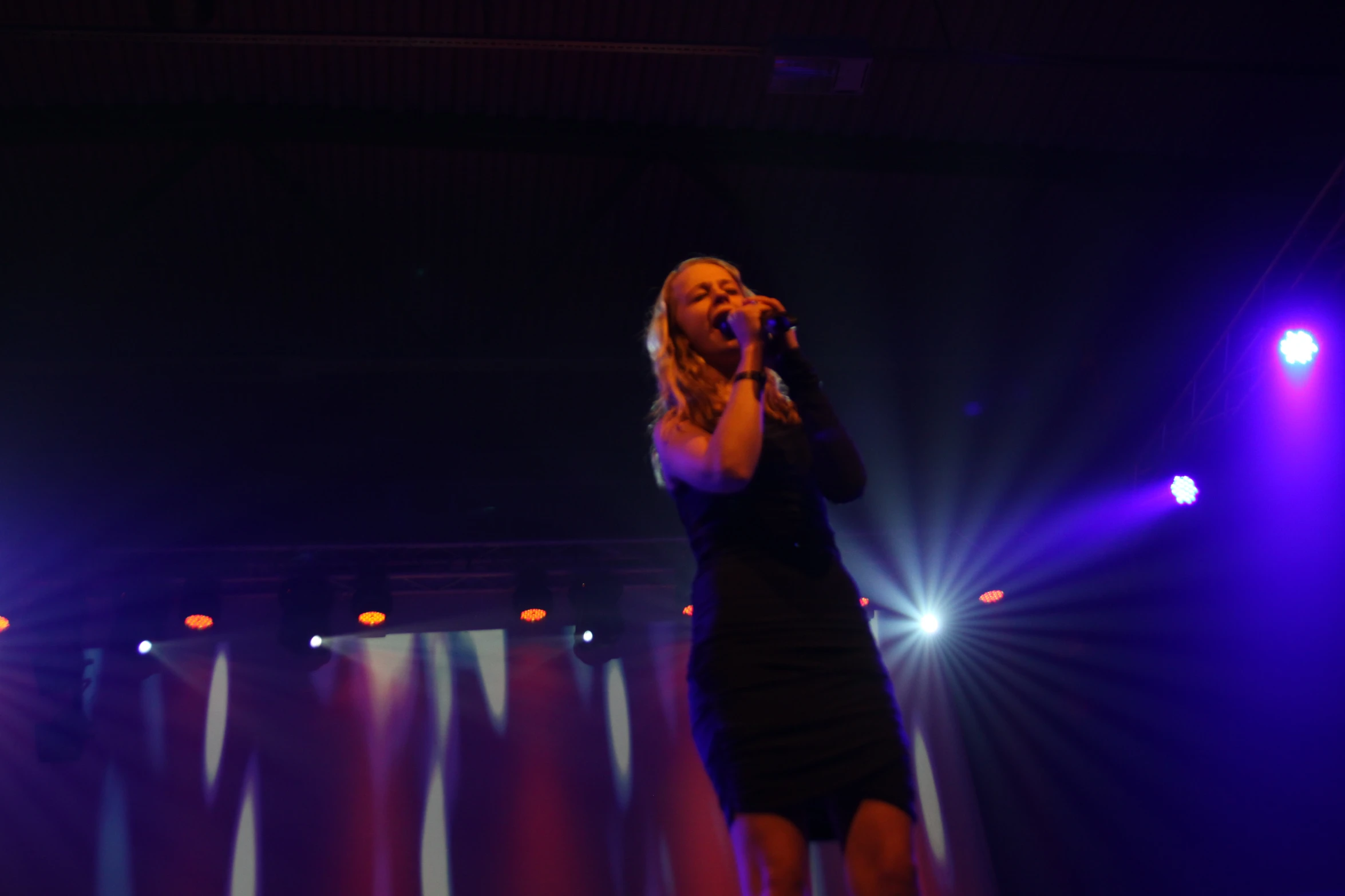 a woman singing on stage at a concert