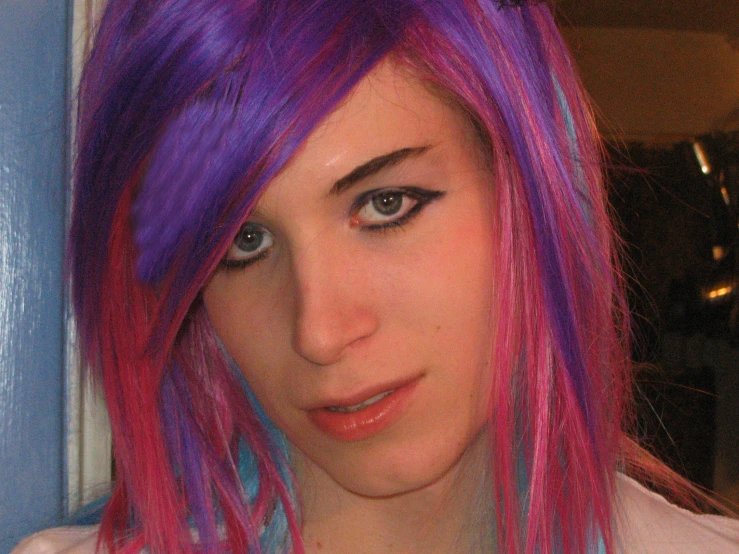 a woman with a blue and pink top and multicolored hair