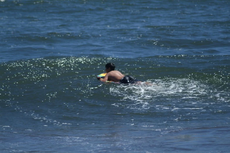 a woman playing frisbee in the ocean on top of the wave