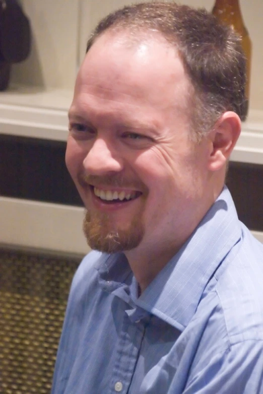 a man with long hair smiling at the camera