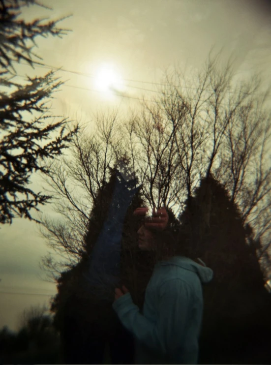 a person with a snowboard standing in front of some trees