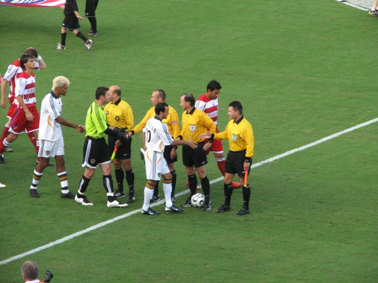 a group of men stand together while talking to each other